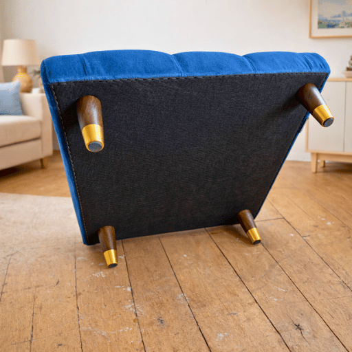 Luxe capitonné ottoman hocker in diepe blauwe kleur met houten poten. Perfect als voetenbank, extra zitplaats of stijlvolle blikvanger in de woonkamer.